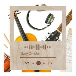 Drewniana ramka Spotify ze sklejki z grawerem piosenki Adele Easy On Me otoczona instrumentami muzycznymi.