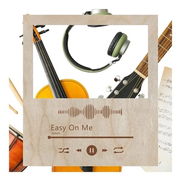 Drewniana ramka Spotify ze sklejki z grawerem piosenki Adele Easy On Me otoczona instrumentami muzycznymi.