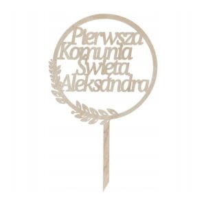 Topper na Komunię z Imieniem Dziecka Drewniana Dekoracja Tortu z napisem Pierwsza Komunia Święta Aleksandra w okrągłej ramce z gałązką.