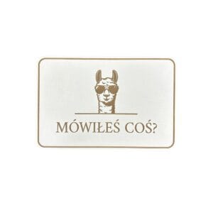 Biała tabliczka dekoracyjna Alpaka Mówiłeś Coś? z płyty HDF o wymiarach 15x10 cm z motywem alpaki w okularach.