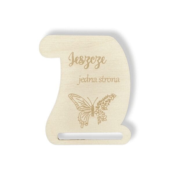 Drewniana baza do zakładki do książki o wymiarach 8 x 6,7 cm z grawerem zwoju, motyla i napisu "Jeszcze jedna strona".