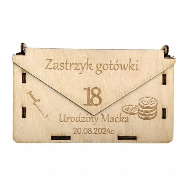 Drewniane pudełko koperta o wymiarach 17 x 10 cm z grawerem „Zastrzyk gotówki” na 18. urodziny Maćka.