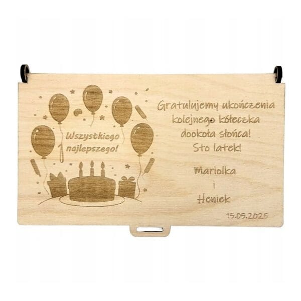 Drewniane pudełko koperta z grawerem na urodziny ma wymiary 18,5 cm x 10,5 cm i jest ozdobione motywem balonów, tortu oraz życzeniami.
