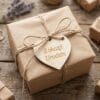 Drewniane Serce z Grawerem Personalizowana Zawieszka 6 x 6 cm ze Sklejki przymocowana sznurkiem do zapakowanego w brązowy papier prezentu urodzinowego.
