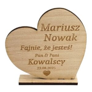 Drewniane winietki ślubne w kształcie serca z grawerowanym imieniem gościa i datą wesela, osadzone na stabilnej podstawce.