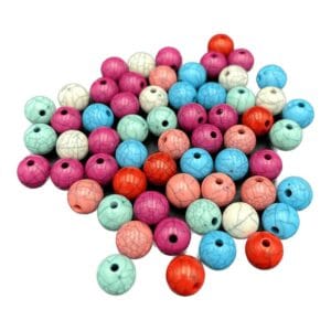 Koraliki marmurkowe plastikowe 10 mm w zestawie 60 sztuk o różnorodnych kolorach rozłożone na płaskiej powierzchni.