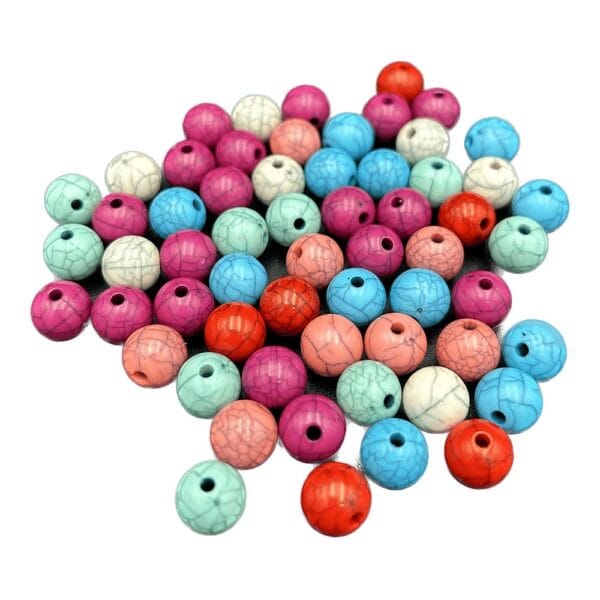 Koraliki Marmurkowe Plastikowe 10 mm 60 szt Koraliki marmurkowe plastikowe 10 mm w zestawie 60 sztuk o różnorodnych kolorach rozłożone na płaskiej powierzchni.