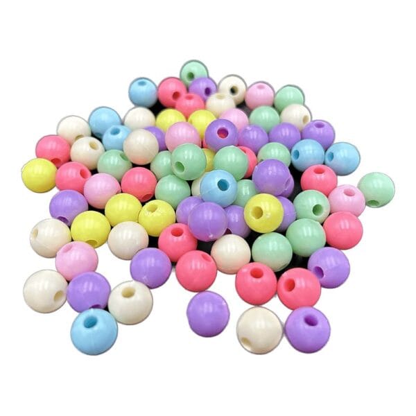 Koraliki Plastikowe Pastel Mix Ø10 mm 80 szt do Biżuterii DIY Koraliki plastikowe pastel mix Ø10 mm do biżuterii DIY w liczbie 80 sztuk wysypane na płaskiej powierzchni.