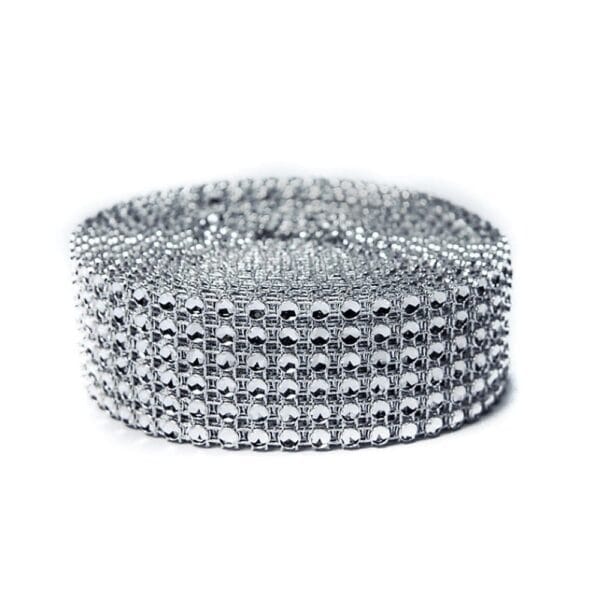 Srebrna Taśma Dekoracyjna Diamentowa Imitująca Cyrkonie 3 cm x 4,5 m Srebrna taśma dekoracyjna diamentowa imitująca cyrkonie 3 cm x 4,5 m zwinięta w rolkę na białym tle.